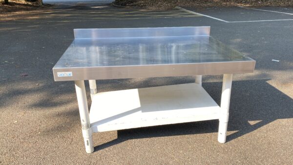 A Small Stainless Steel Low Table With White Stand