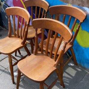 Four honey coloured solid pine country style dining chairs