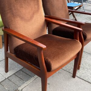 Two brown fireside chairs with teak coloured arms